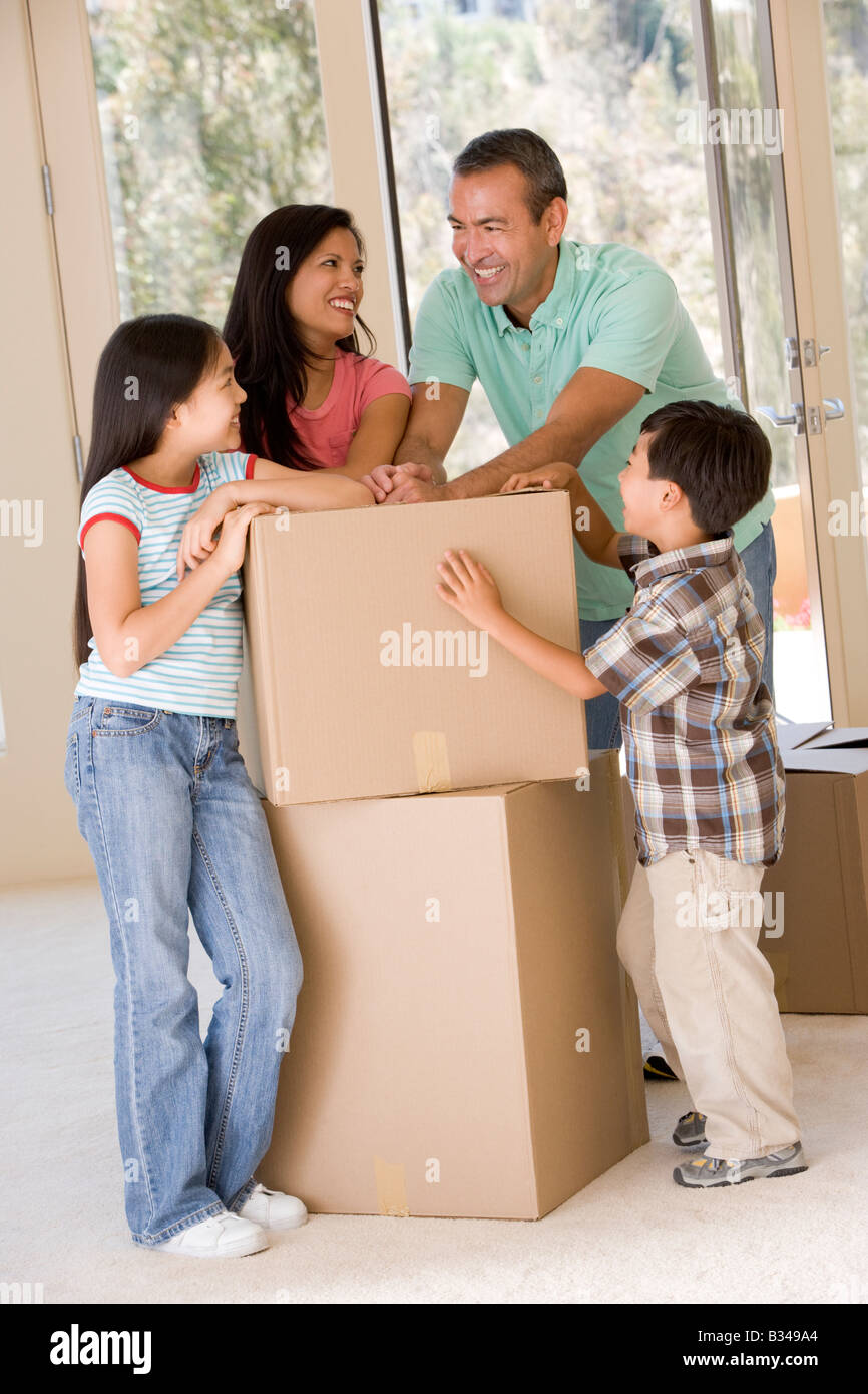 Familie mit Boxen im neuen Hause lächelnd Stockfoto