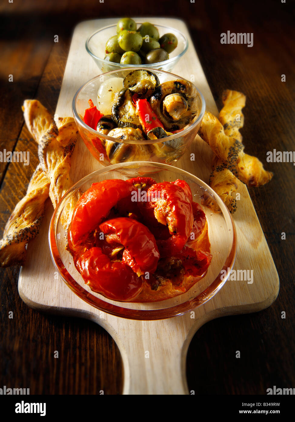Antipasti - errötete Sonne, Tomaten, Champignons und gebratenes Gemüse und Oliven mit Brot-Sticks. Stockfoto
