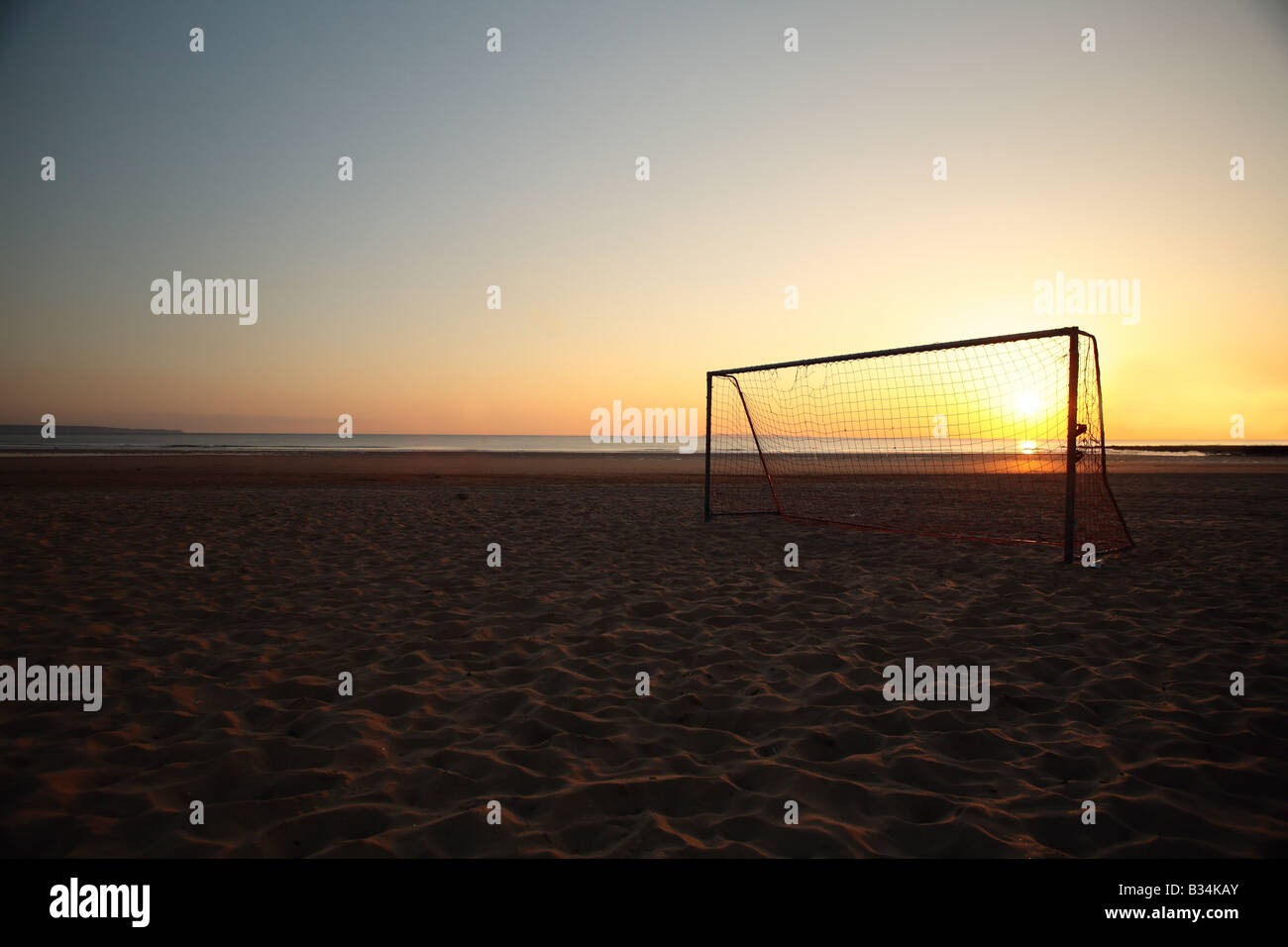 Beach-Fußball Netto bei Sonnenuntergang Stockfoto