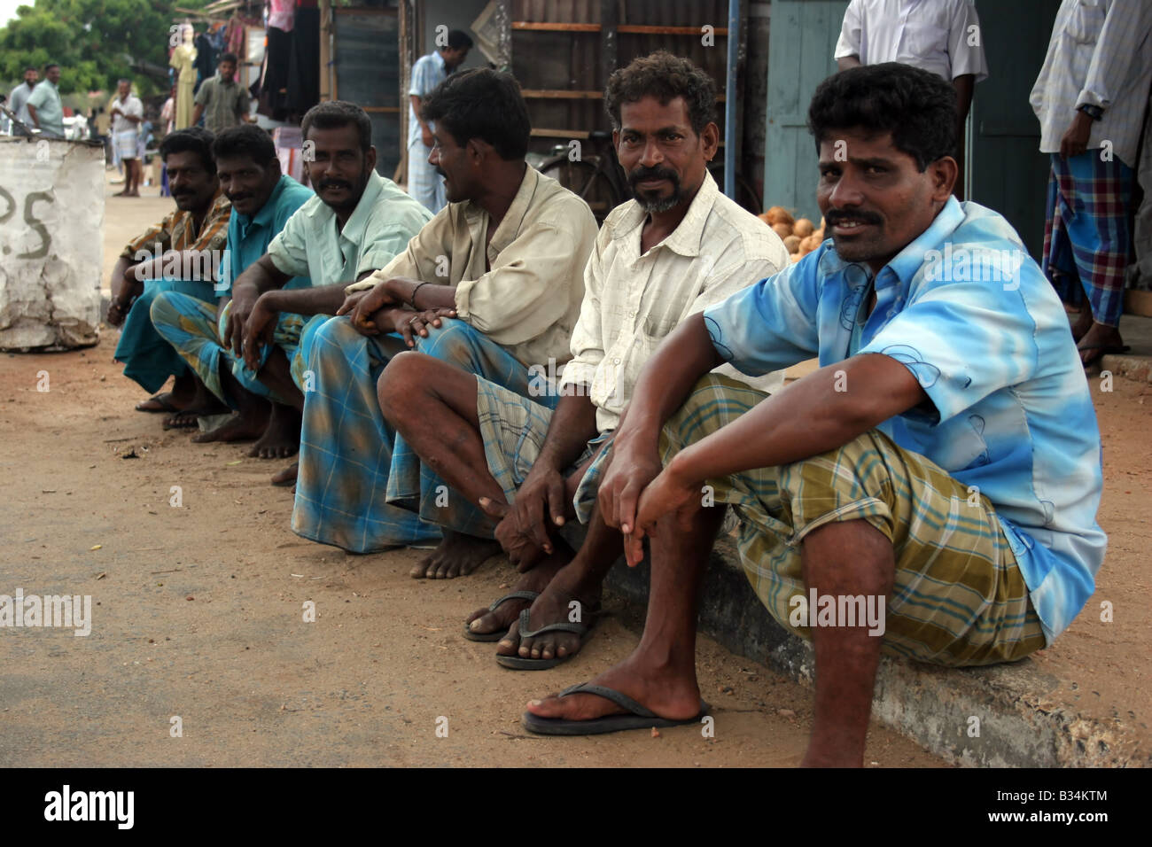 Einheimische Männer sitzen und entspannen auf dem Weg in Mannar Stadt, Sri Lanka Stockfoto