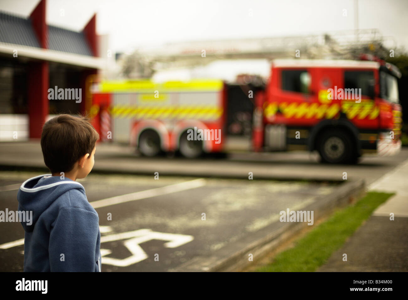 Sechs Jahre alter Junge schaut Feuerwehrauto außerhalb Feuerwache in Palmerston North New Zealand Stockfoto