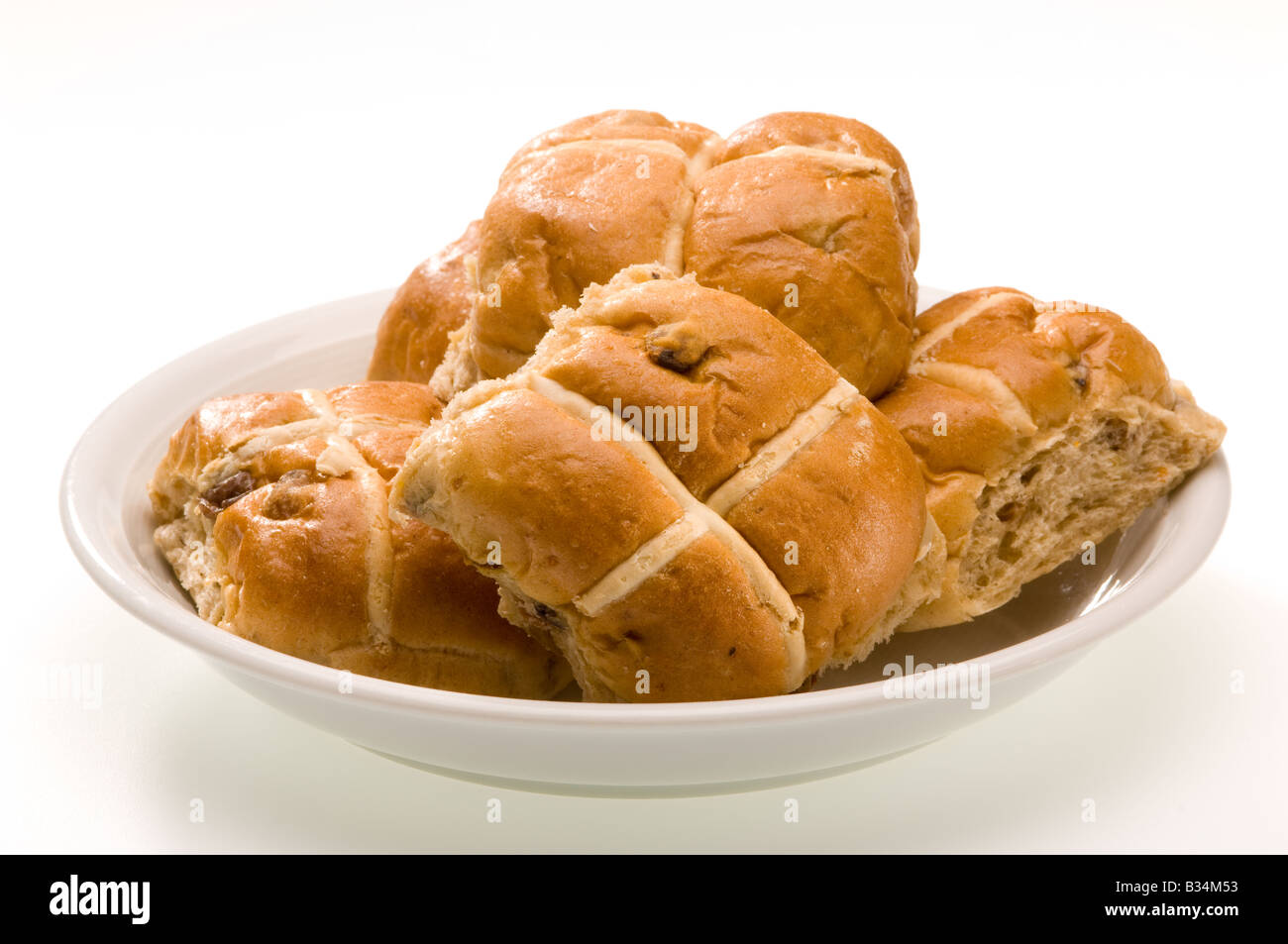 Kommerziell gebackene Hot-Cross-Brötchen auf einem weißen Teller. UK Stockfoto