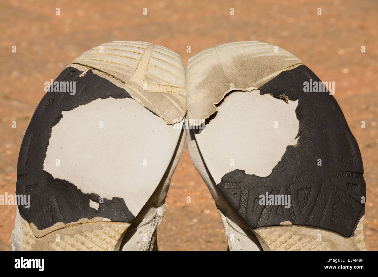 Ein paar der alten abgenutzt Trainingsschuhe auf einer Terrasse Stockfoto