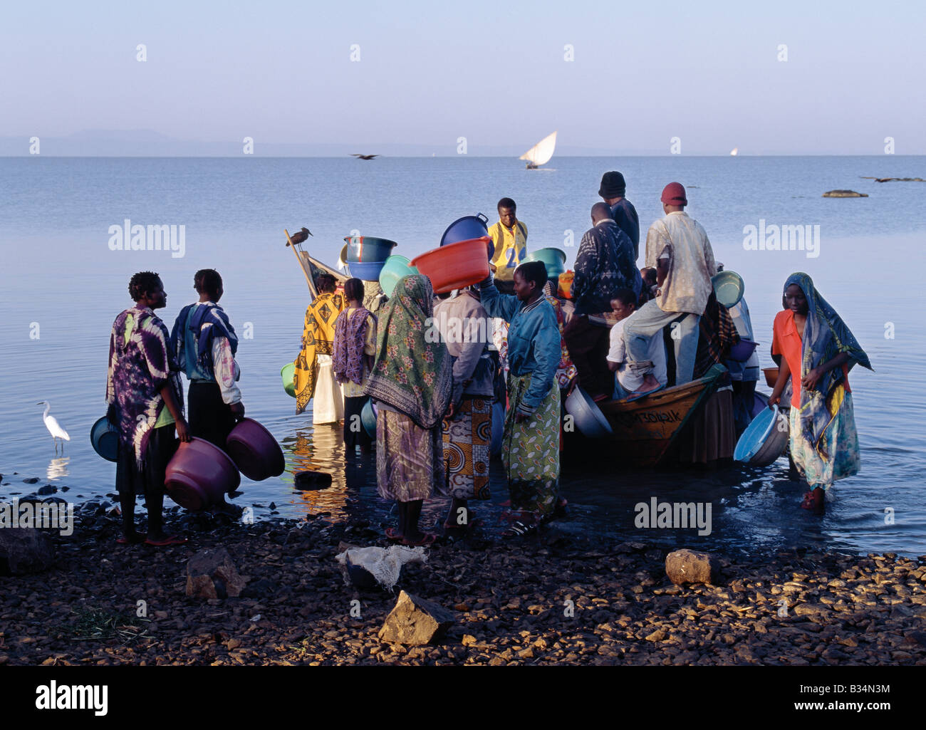 Kenia, Provinz Nyanza, Kisumu. Die ganze Nacht gefischt im seichten Wasser des Lake Victoria Kavirondo Golf in der Nähe von Kisumu, zurück Fischer Dunga Strand kurz nach Sonnenaufgang wo drängeln sich Männer und Frauen, um ihren Fang von Tilapia, Viktoriabarsch und die kleinen Engraulicypris Arten zu kaufen. Die meisten Bootsbesitzer haben zwei Mannschaften um ihr Handwerk zu einen 24-Stunden-Zyklus arbeiten zu ermöglichen. Stockfoto