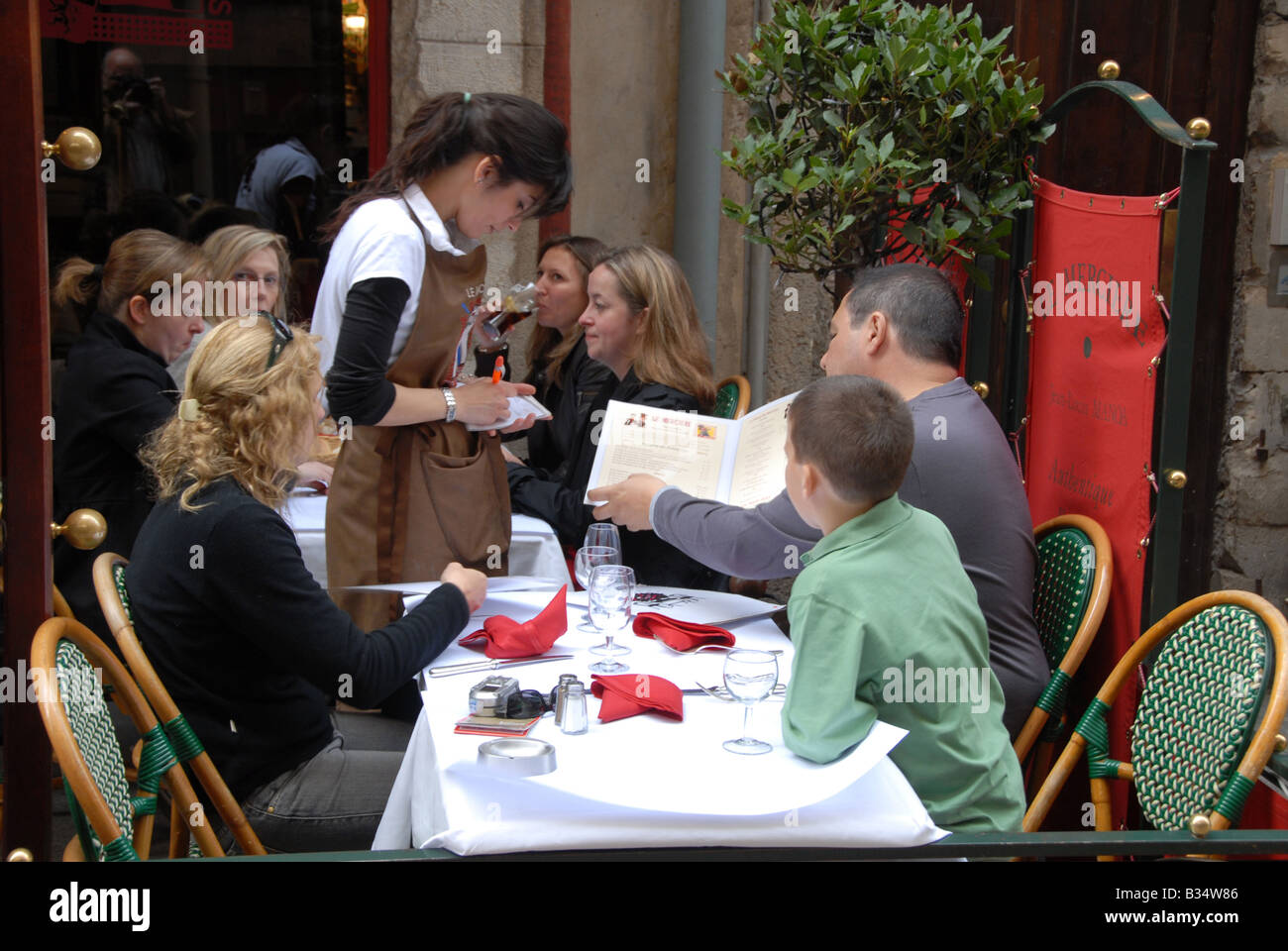 Ein Kellner nimmt ein Mittagessen bestellen aus einer Familie in einem der Restaurants in der Rue Merciere, Lyon, Frankreich Stockfoto