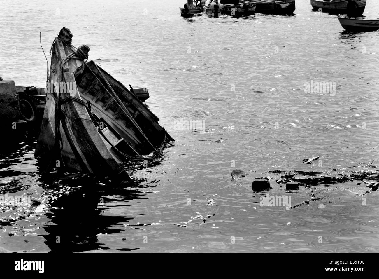 Schwarz / weiß Foto von Broken Boot am Seehafen Stockfoto