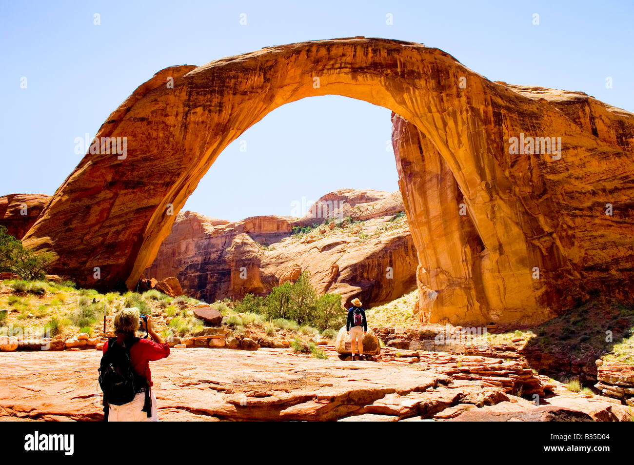 Besucher, die den natürlichen Sandstein Bogen am Rainbow Bridge National Monument Utah zu fotografieren Stockfoto