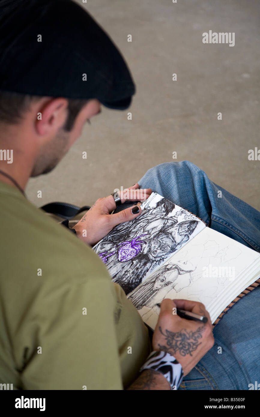 Spanien Barcelona Mann sitzen im Parc Güell und Federzeichnungen im Skizzenbuch zu erstellen Stockfoto