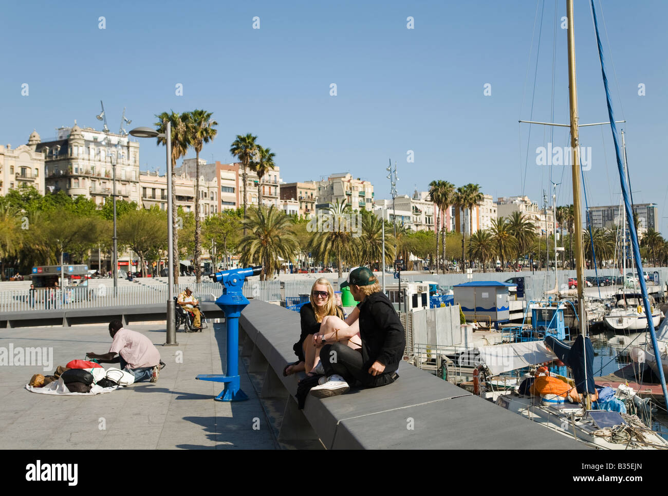 Spanien Barcelona junge Paar Sit auf Betonwand Segelboote im Hafen von Marina Port Vell Straße Verkäufer verteilt waren auf Bürgersteig Stockfoto
