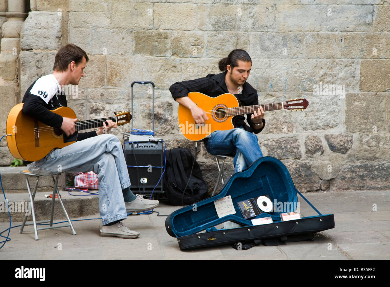 Spanien Barcelona zwei junge Erwachsene Männer spielen Akustikgitarre im Plaza mit offenen Gitarrenkoffer, Verkauf von Musik-CDs Stockfoto