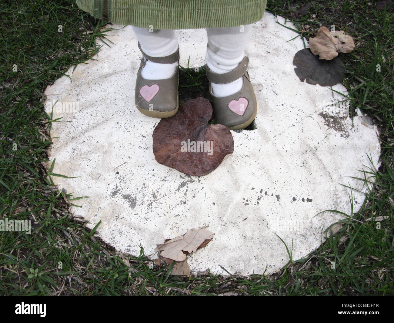 Nahaufnahme mit Childs Füße mit niedlichen Schuhe stehen auf einer Zement-Kreis Stockfoto