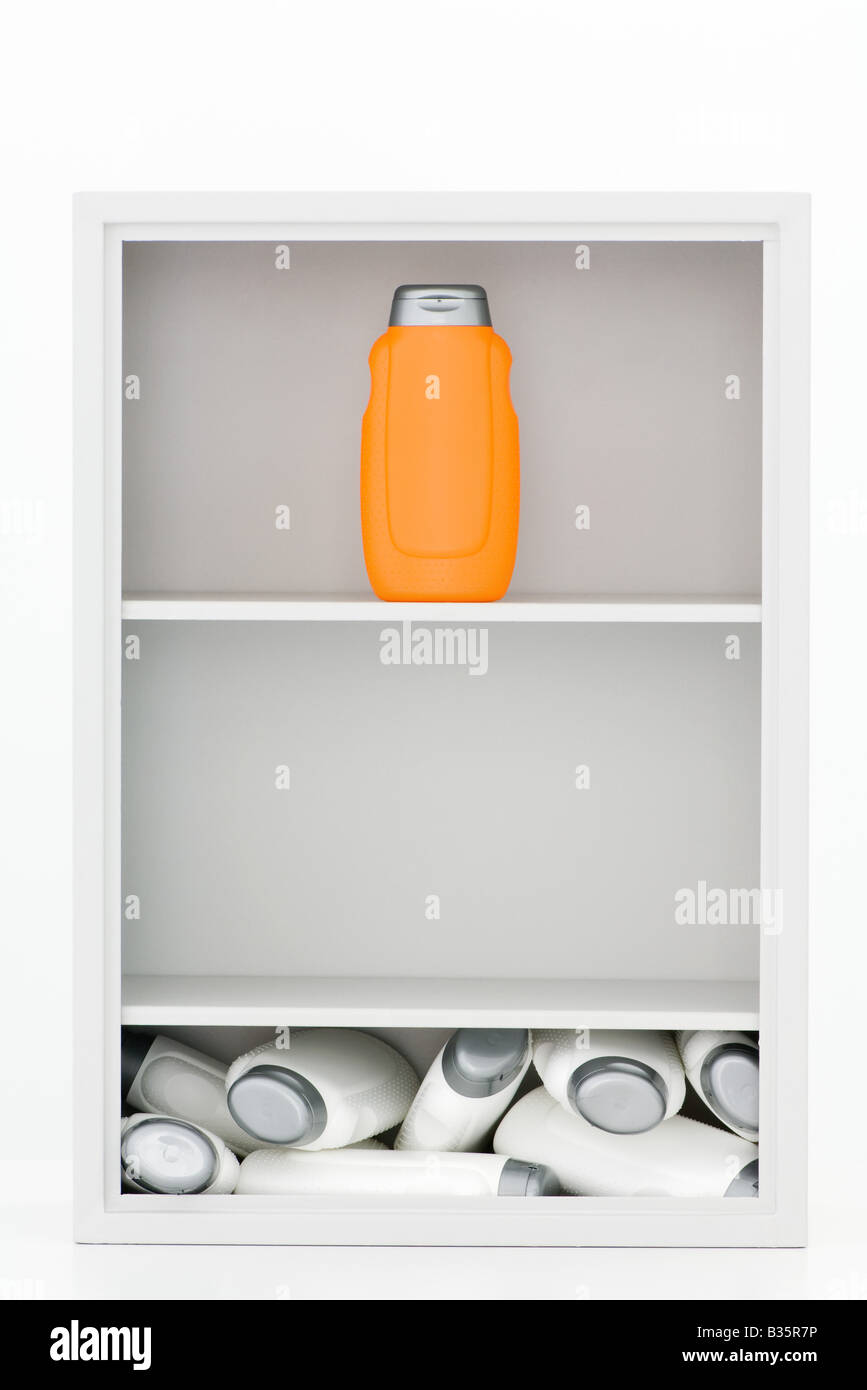 Flaschen in Hausapotheke, weiß viele Flaschen in ein Durcheinander auf dem Boden, eine orange Flasche steht auf dem obersten Regal Stockfoto