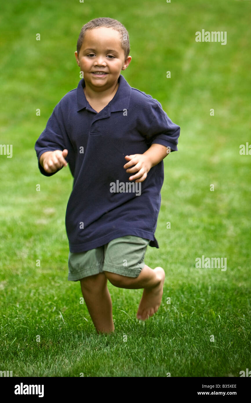 Junge Latino Boy außerhalb über Wiesen laufen Stockfoto