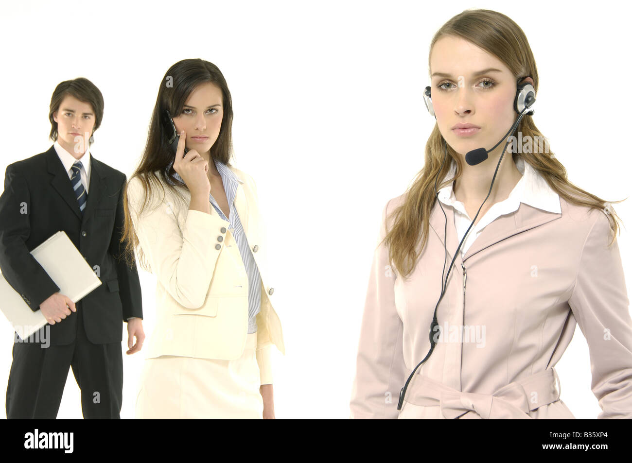 Porträt von einem weiblichen Kundendienstmitarbeiter sprechen über einen Kopfhörer mit ihren Kollegen, die hinter ihr stehen Stockfoto