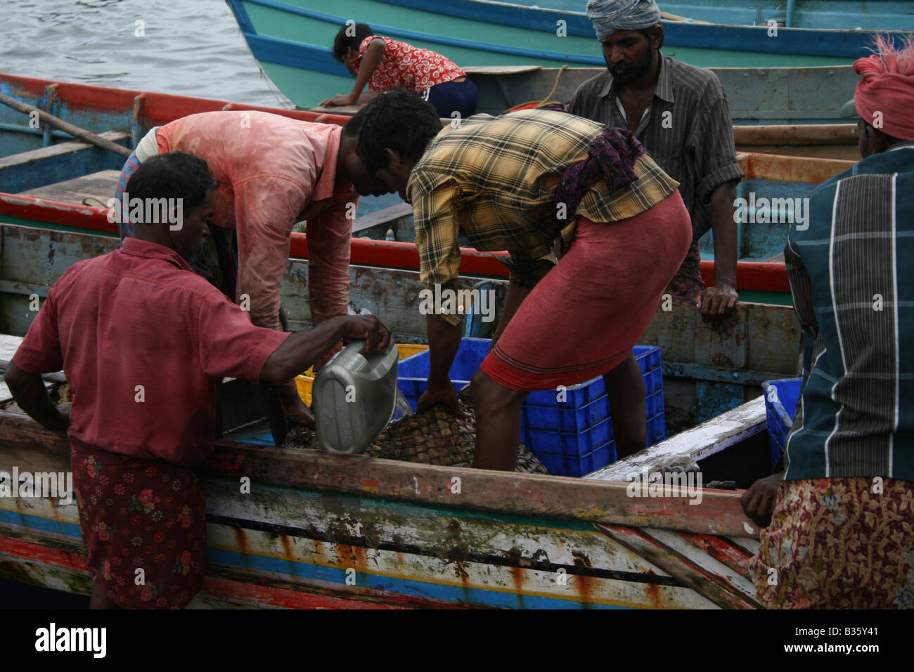Indische Fisermen Trivandrum Kerala Indien entladen Fische und Tintenfische vom Boot zum Verkauf auf dem Markt Stockfoto
