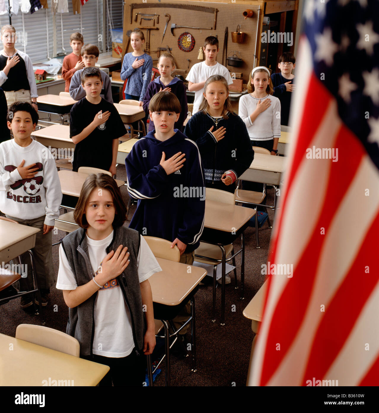 Grundschulkinder rezitieren The Pledge of Allegiance, die amerikanische Flagge Stockfoto