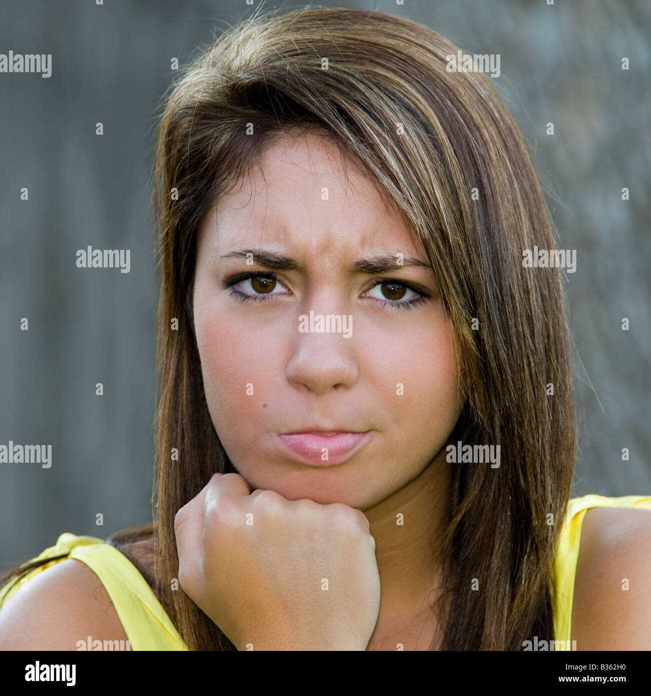 Ein hübsche, braune Haare, braune Augen, 16 Jahre alt Mädchen in einem  gelben Kleid mit einem Schmollmund Ausdruck auf ihrem Gesicht  Stockfotografie - Alamy