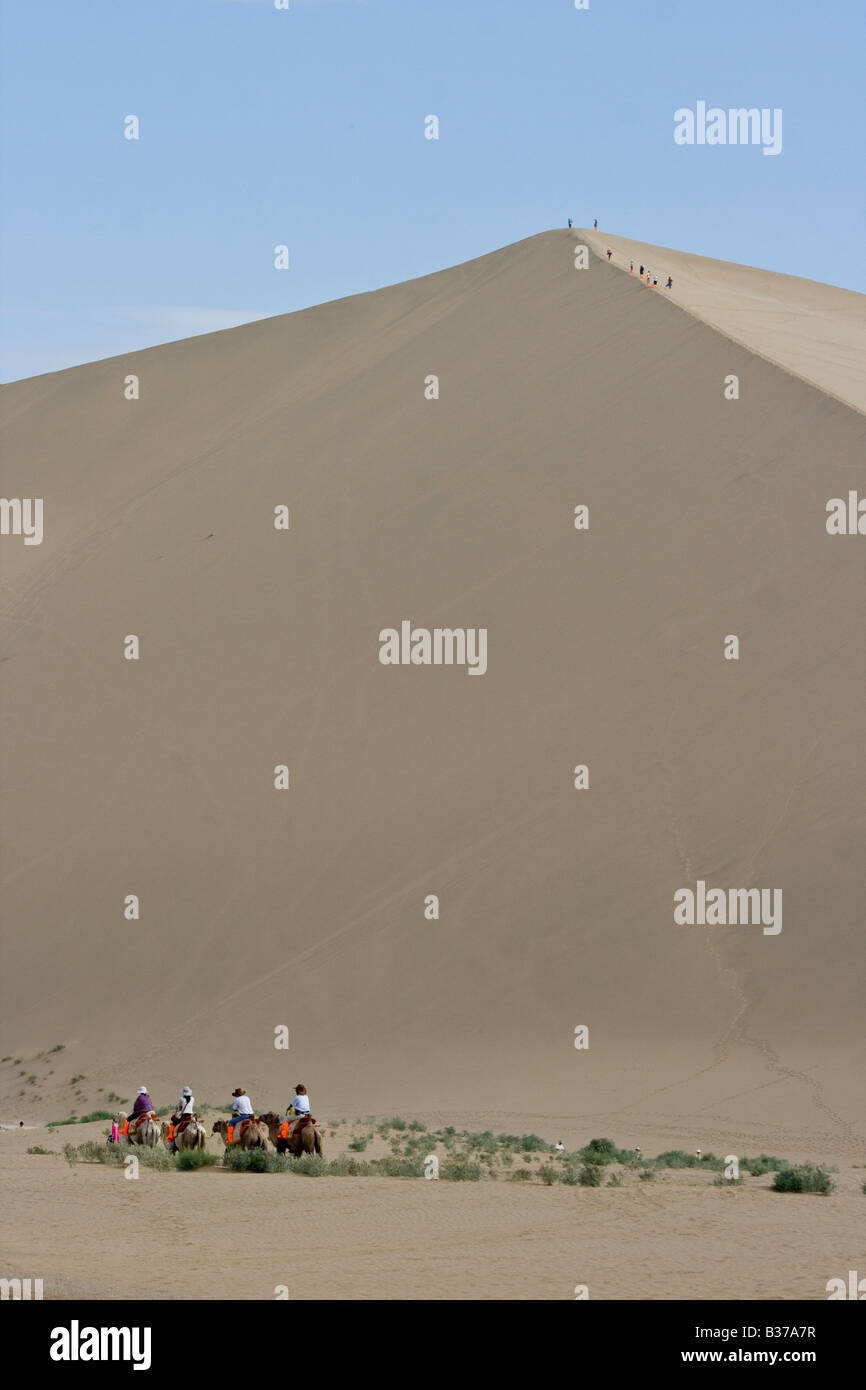 Touristischen Kamelritt auf den Singing Sands Berg Sanddünen in Dunhuang China Stockfoto