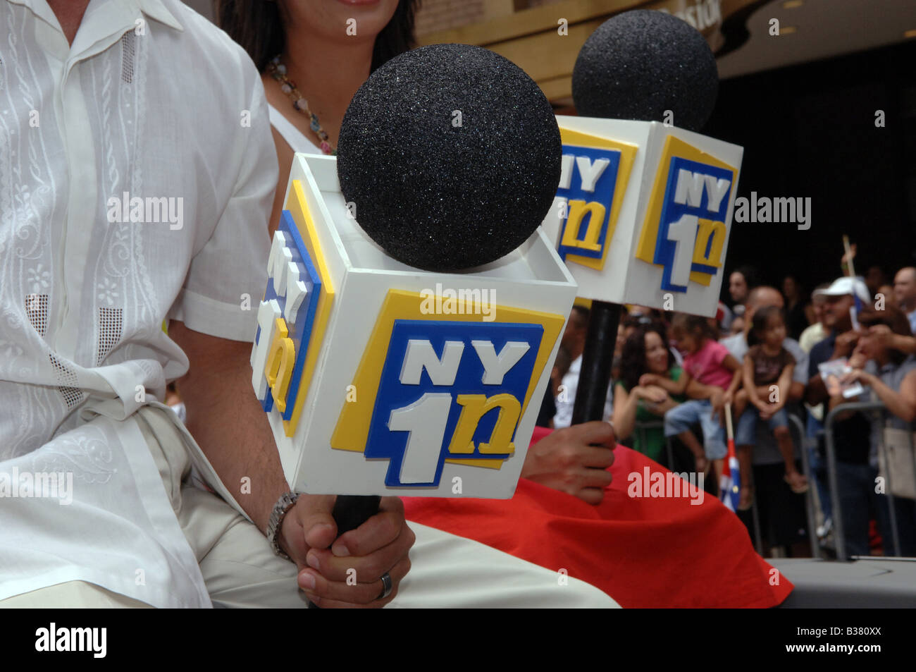 Sender von NY1 En Espanol tragen übergroße mock Mikrofone Stockfoto