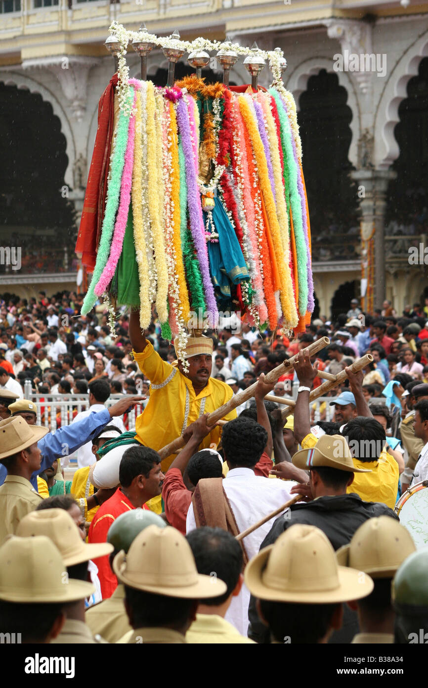 Ein Mann steigt auf über Polizisten, die entlang der Route der Dasara Prozession in Mysore, Indien. Stockfoto