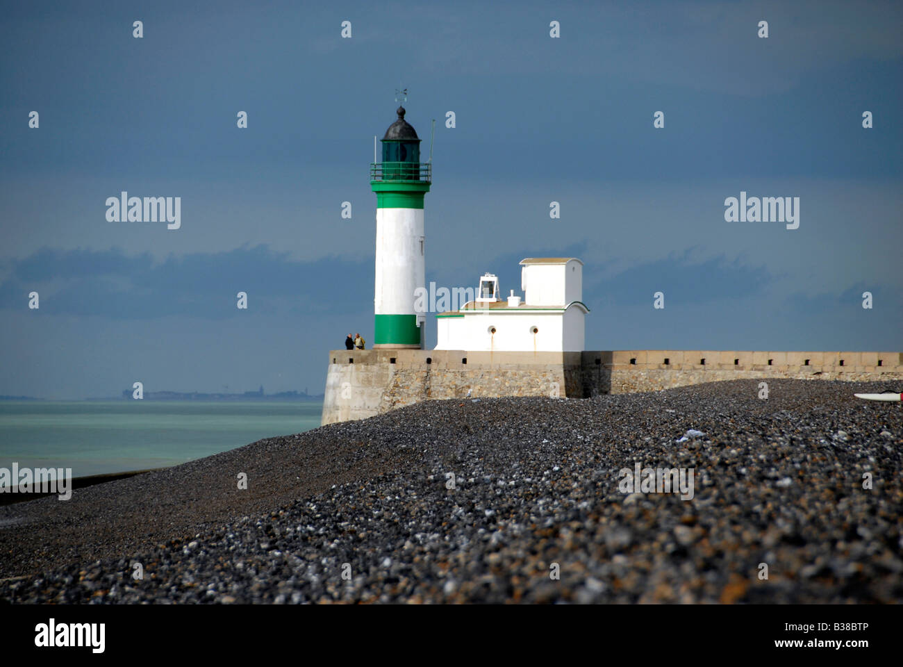 Leuchtturm beleuchtet von der untergehenden Sonne mit Wolken in den Himmel am Strand von Le Treport in der östlichen Normandie, Frankreich Stockfoto