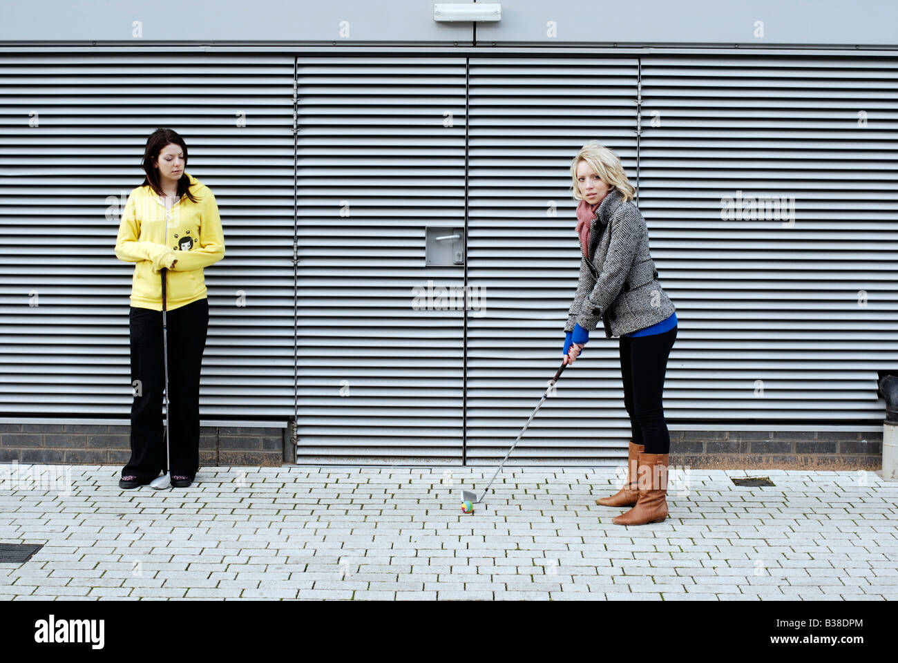 Junge Frauen urban Golf spielen in der Stadt Stockfoto