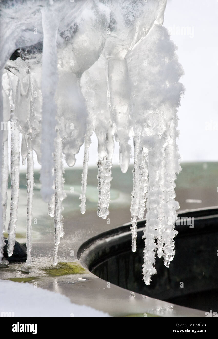Eiszapfen hängen bedeckt im weißen Schnee Stockfoto