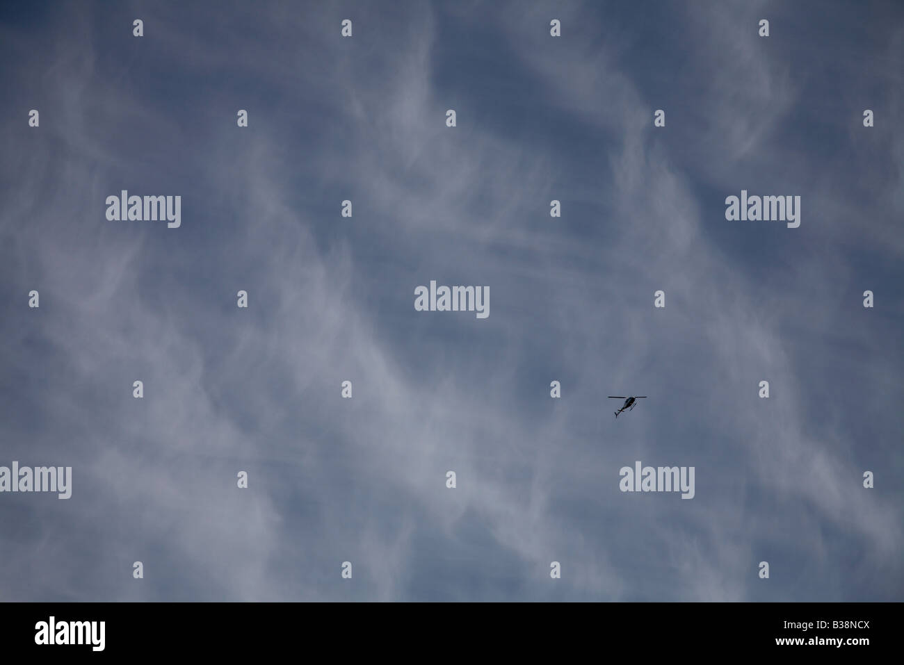 Altocumulus Wolken gegen ein Reich blauer Himmel und eine winzige bekommen Ranger Bell 206 Hubschrauber Stockfoto