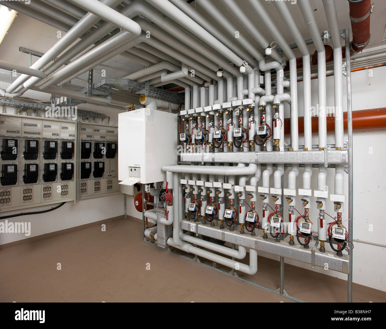 moderne Heizungsanlage mit Rohren in einem Mehrfamilienhaus Stromzähler  hinter Deutschland Stockfotografie - Alamy