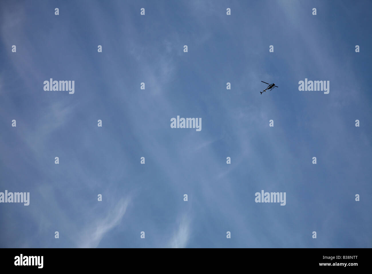 Altocumulus Wolken gegen ein Reich blauer Himmel und eine winzige bekommen Ranger Bell 206 Hubschrauber Stockfoto
