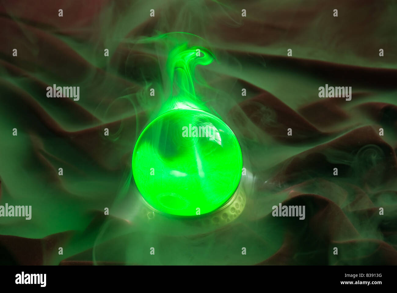 Eine Kristallkugel erwacht als grünes Licht und Nebelform um das Glas Stockfoto