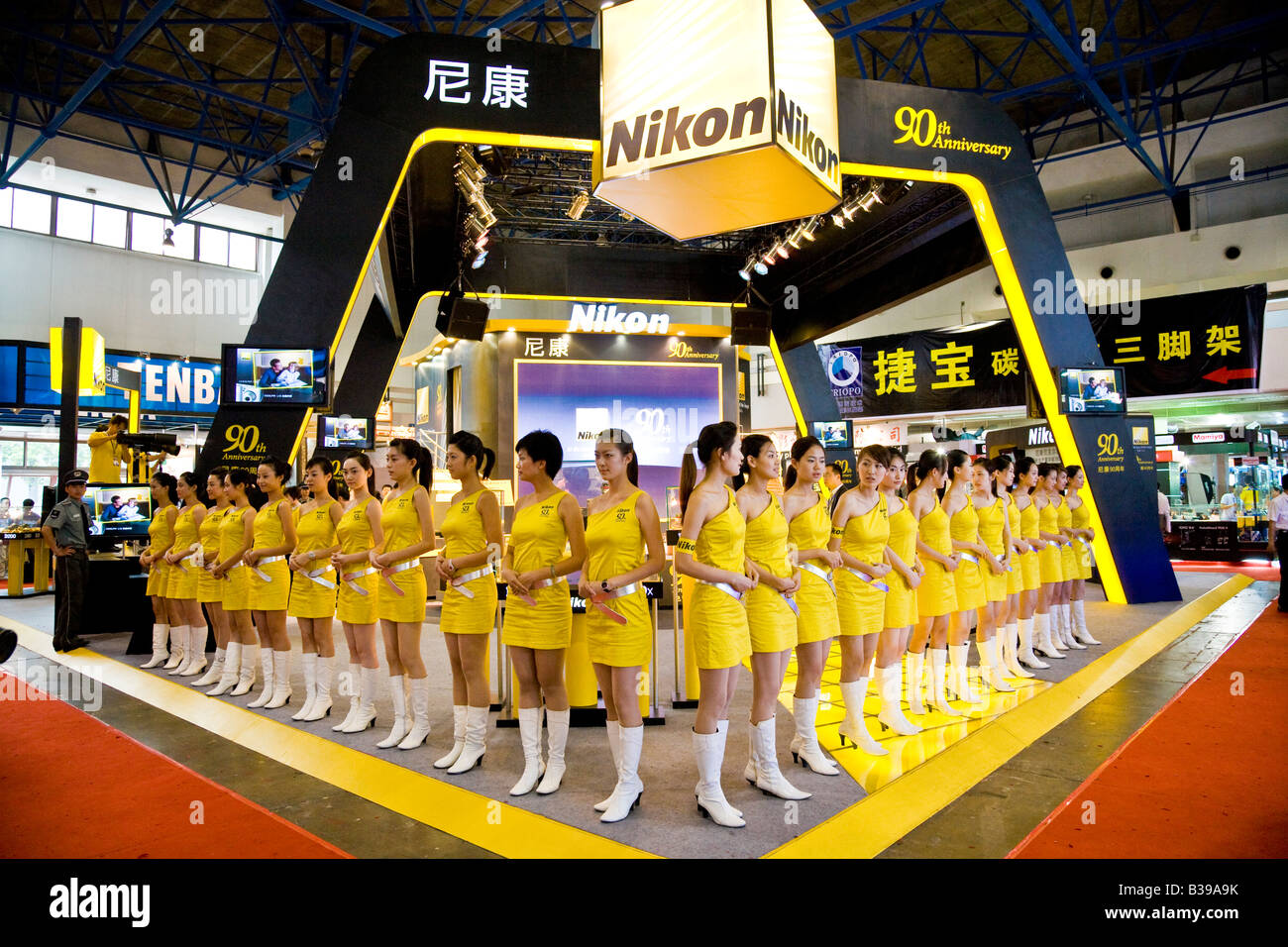 Gruppe von chinesischen Mädchen gekleidet in Nikon gelb uniform auf fotografische Messe Stand in Peking China Juli 2007 JMH3208 Stockfoto