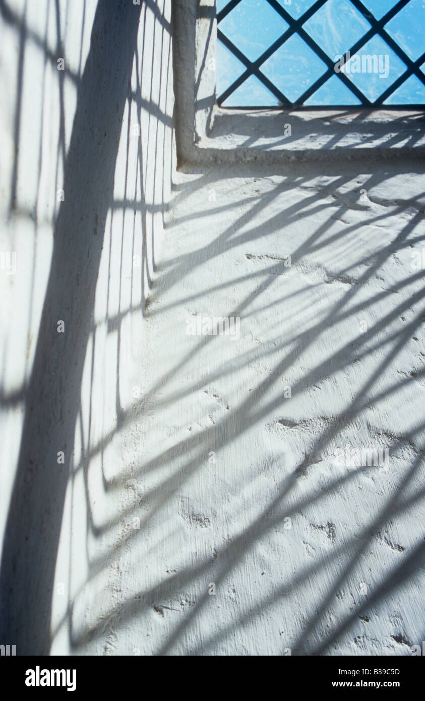 Projektion von deutlich kleiner Diamant verbleit Glasscheiben Fenster auf Seiten Creme lackiert rauhe Aussparung mit blauem Himmel sichtbar Stockfoto