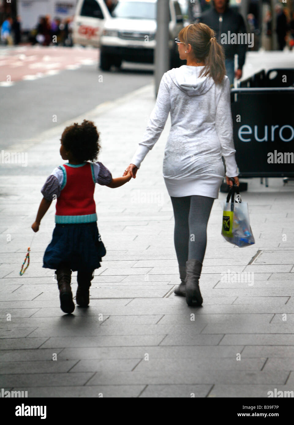 Ein kleines Afro Mädchen mit Betreuer auf der Straße Stockfoto