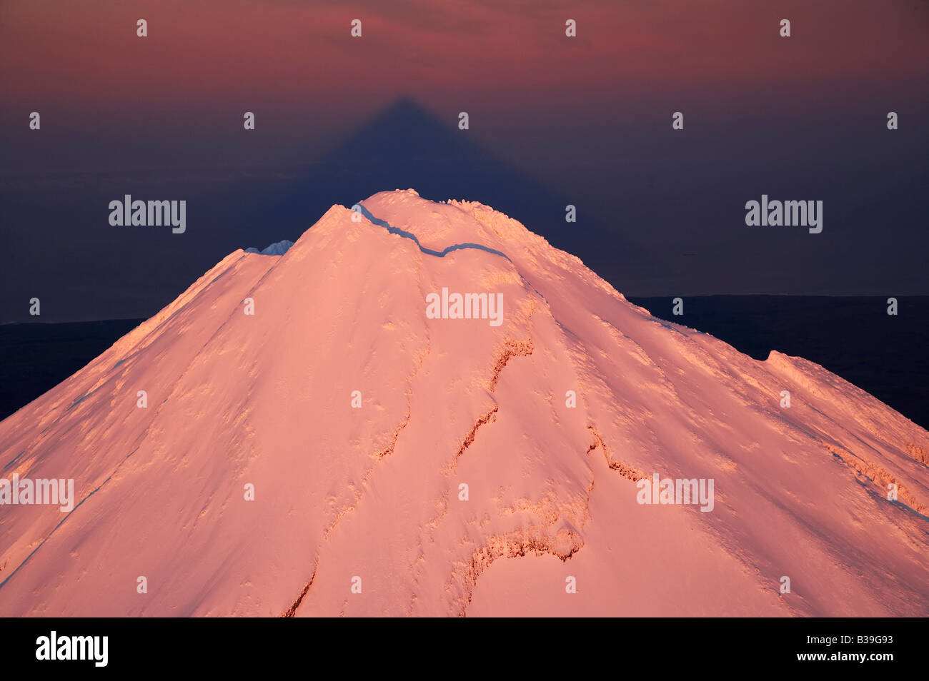 Alpenglühen am Gipfel des Mt Taranaki Mt Egmont bei Dämmerung und Schatten Taranaki Nordinsel Neuseeland Antenne Stockfoto