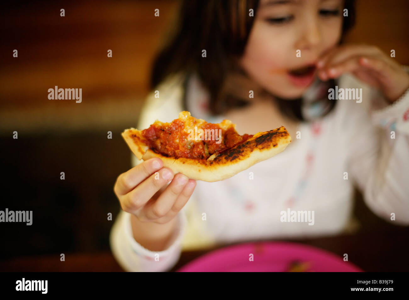 Hausgemachte Pizza fünf Jahre altes Mädchen nimmt Bissen von sehr heißen Pizza frisch aus dem Ofen Stockfoto