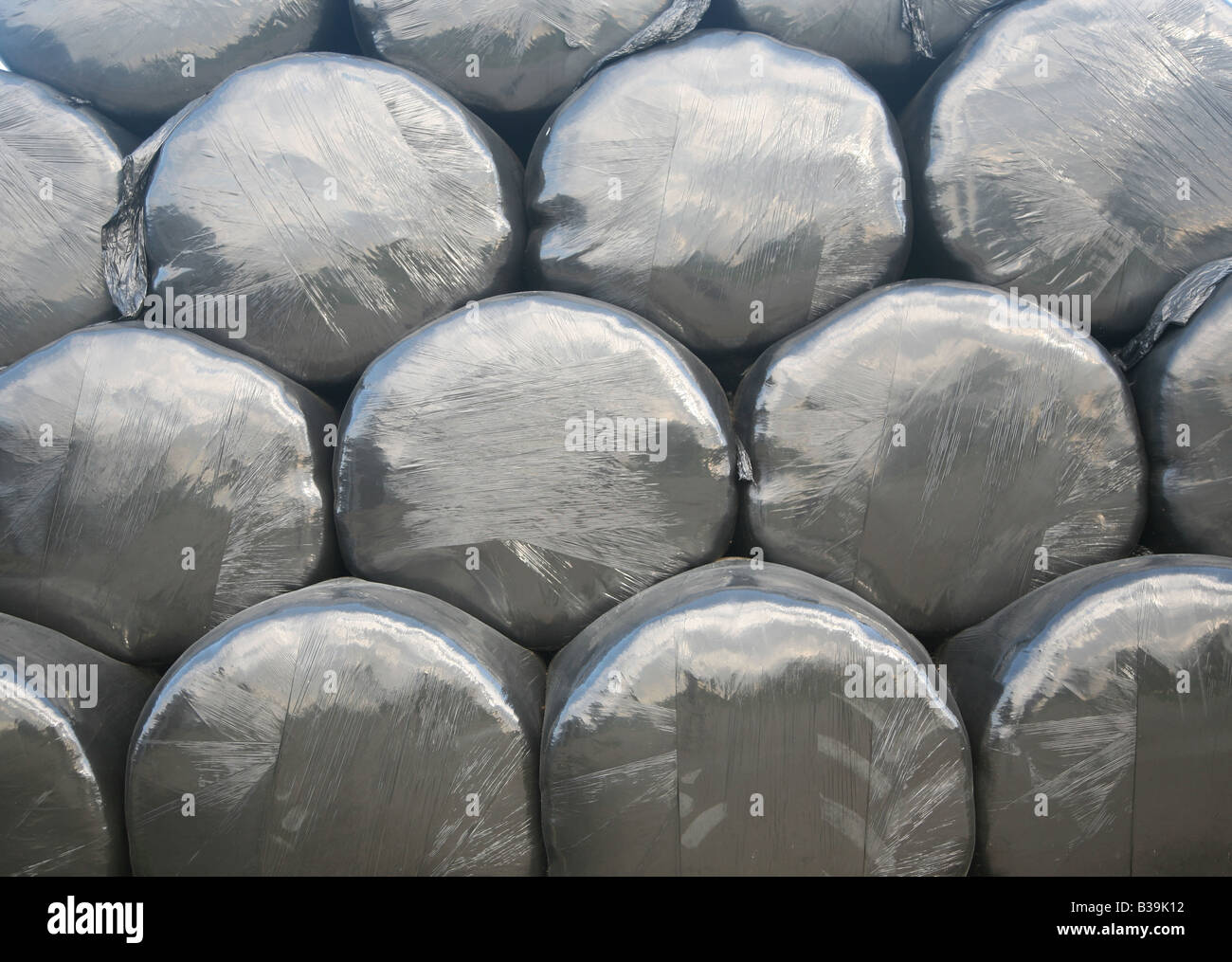 Stapeln von Rundballen Heu in schwarzem Kunststoff-Abdeckungen Stockfoto