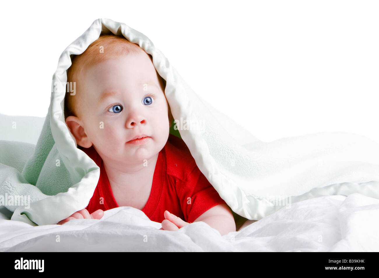 Schöne junge Baby mit roten Haaren auf Front unter weichen Decke liegend Stockfoto