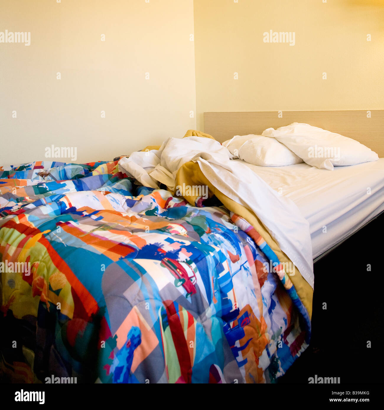 Innenaufnahme der Motelzimmer mit chaotisch ungemachten Bett Stockfoto
