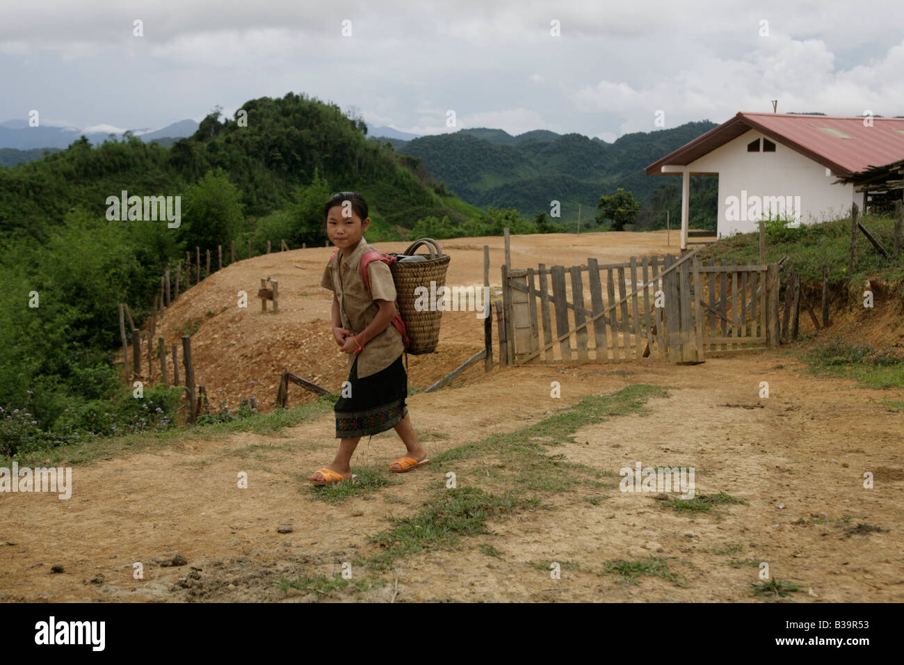 Nong Het District, Provinz Xieng Khouang, Laos. Eine Mädchen geht vorbei an ihrer Schule eröffnet, nachdem MAG Ortsbild des UXO gelöscht. Stockfoto