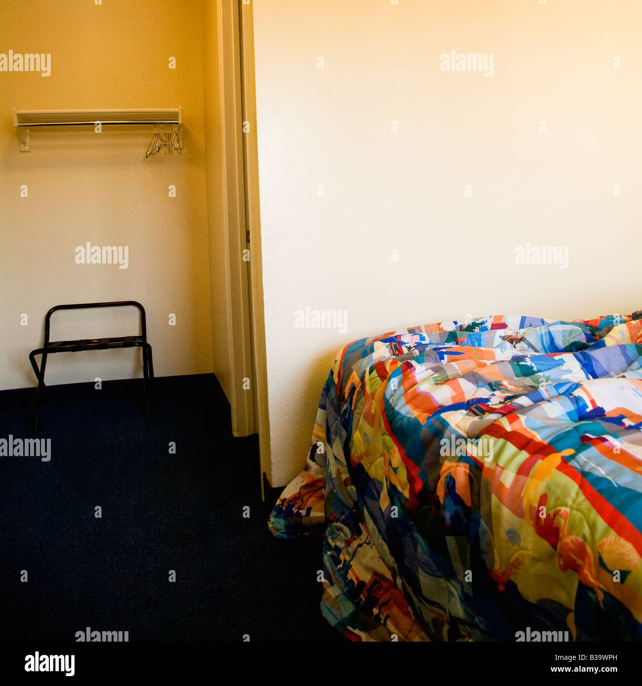 Innenaufnahme der Motelzimmer mit ungemachten Bett und Schrank Stockfoto