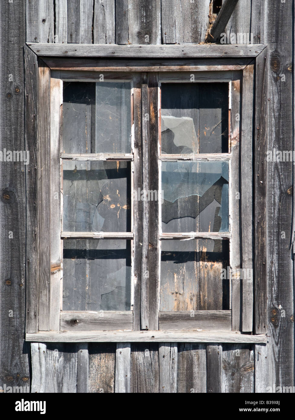 alte hölzerne Scheune Fenster mit Brille geknackt Stockfoto