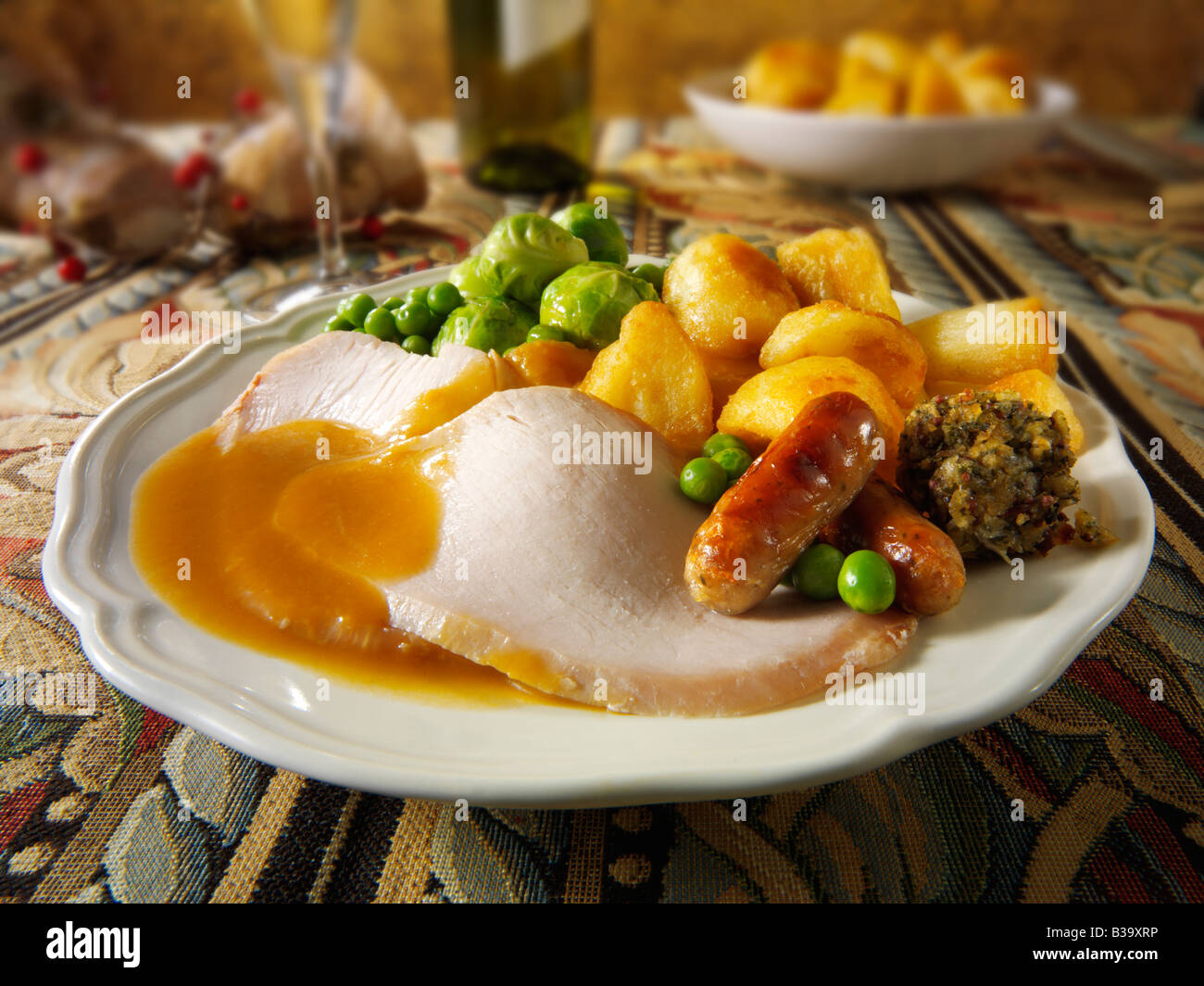 Traditionelles Truthahn-Weihnachtsessen mit allen Zutaten und Bratkartoffeln, überzogen und serviert in festlicher Tischstimmung Stockfoto