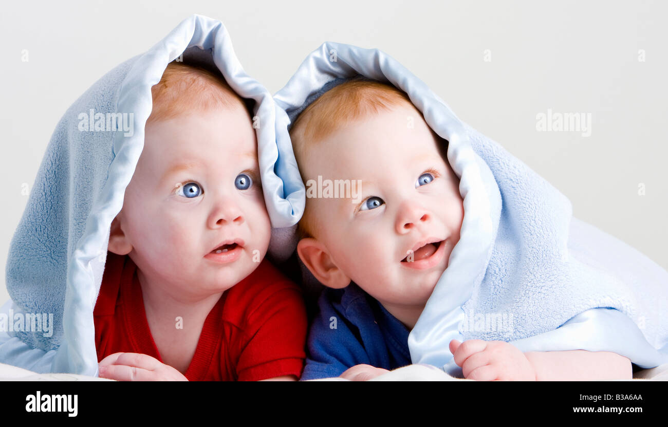 Schöne junge baby Zwillingen mit roten Haaren auf Front unter weichen Decke liegend Stockfoto