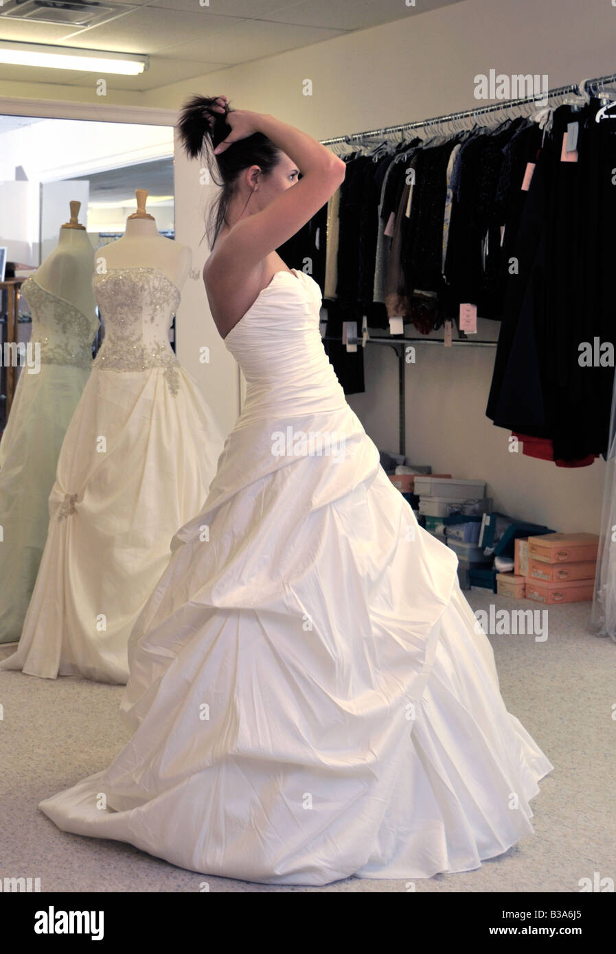 Eine 21 jährige Braut hat eine passende für ihr Brautkleid. Sie sammelt ihr Haar zu sehen wie es aussieht. Stockfoto