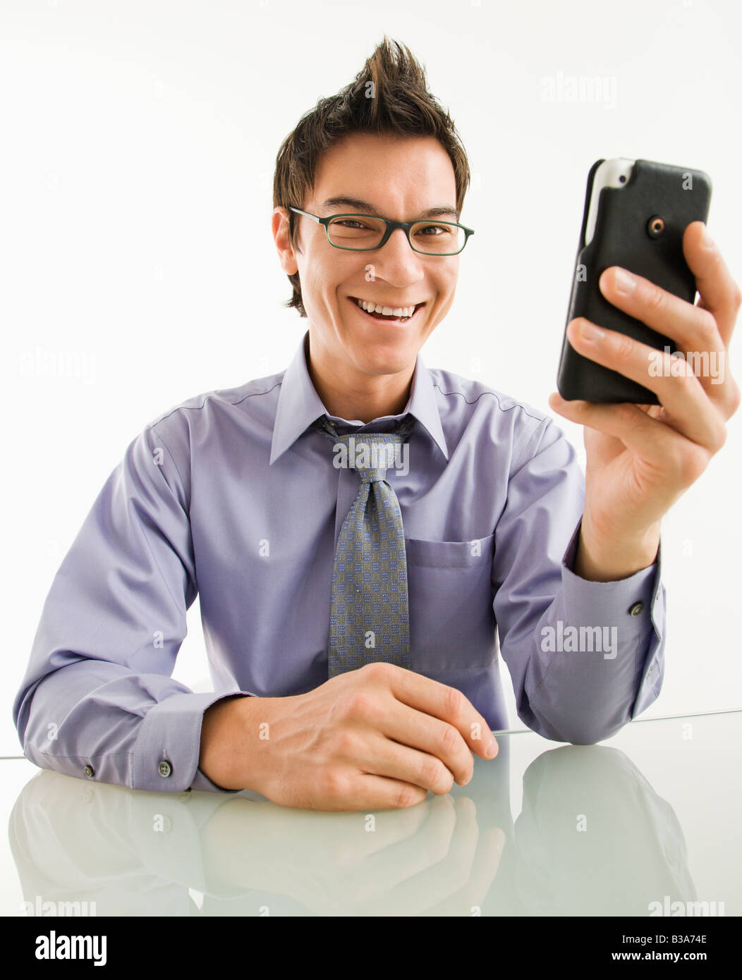 Lächelnde asiatische Geschäftsmann mit seinem Pda Handy Stockfoto