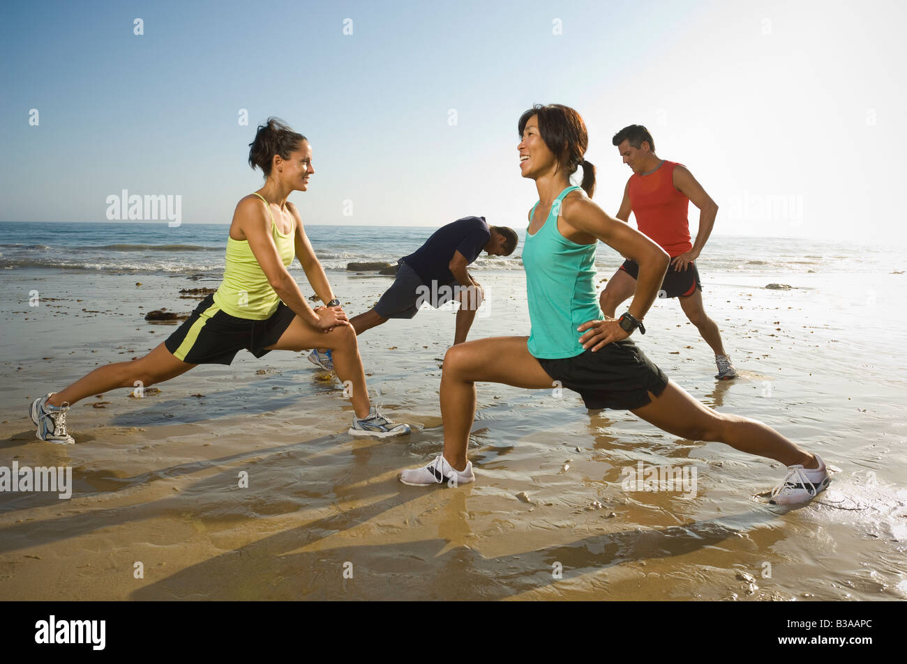 Multi-ethnischen Läufer stretching am Strand Stockfoto