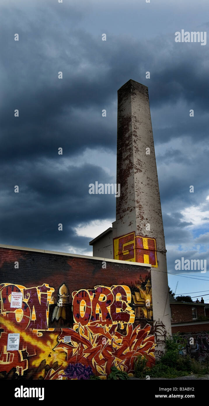 Graffiti auf einem Industriegebäude Mauer gegen einer Gewitterwolke Stockfoto