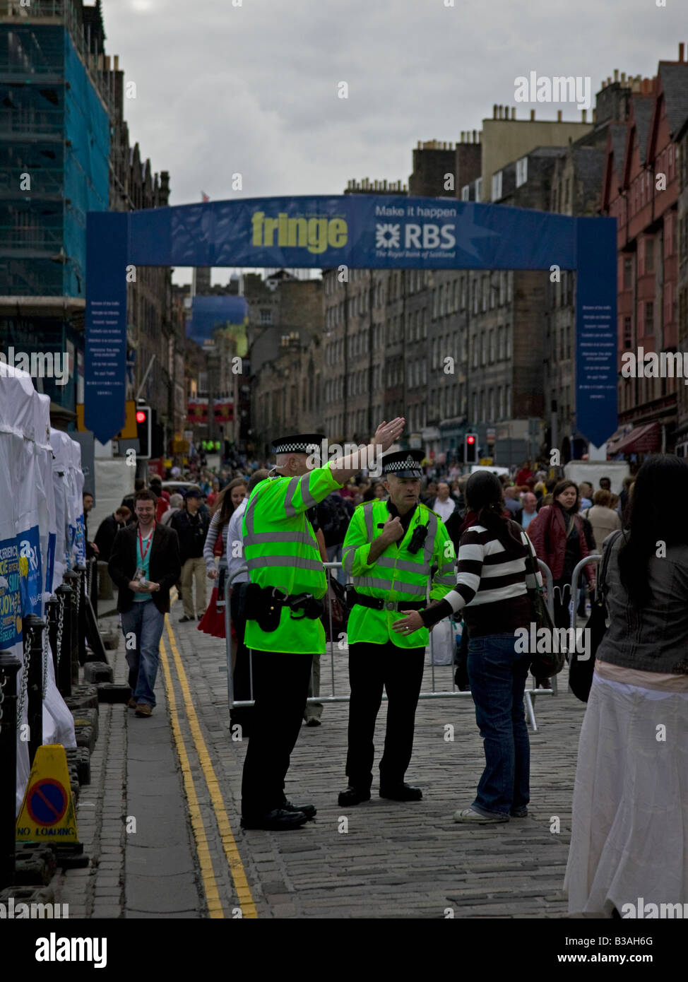 Zwei männliche Polizisten geben Anweisungen, Weiblich, Royal Mile, Edinburgh, Schottland, UK, Europa Stockfoto