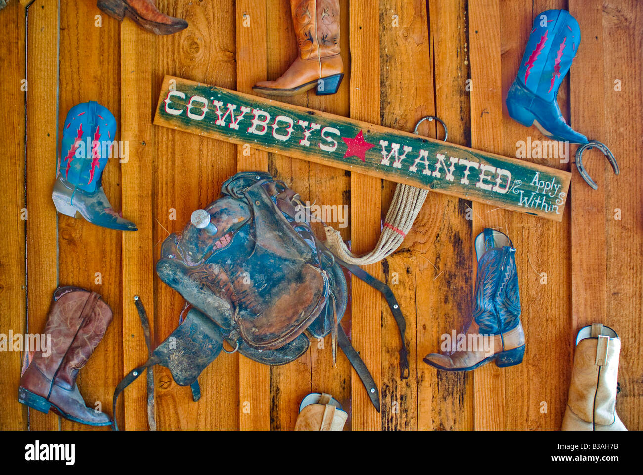 ländliche Cowboys Cowboystiefel Schild hängen an einem alten hölzernen Wand Spaß wollte Reisen, Vereinigte Staaten von Amerika Stockfoto